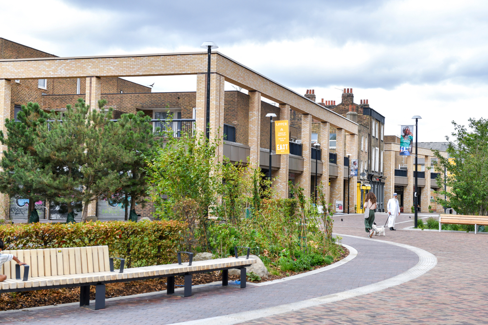 Landscaped green spaces and curved benches beside the Stroudley Walk parade