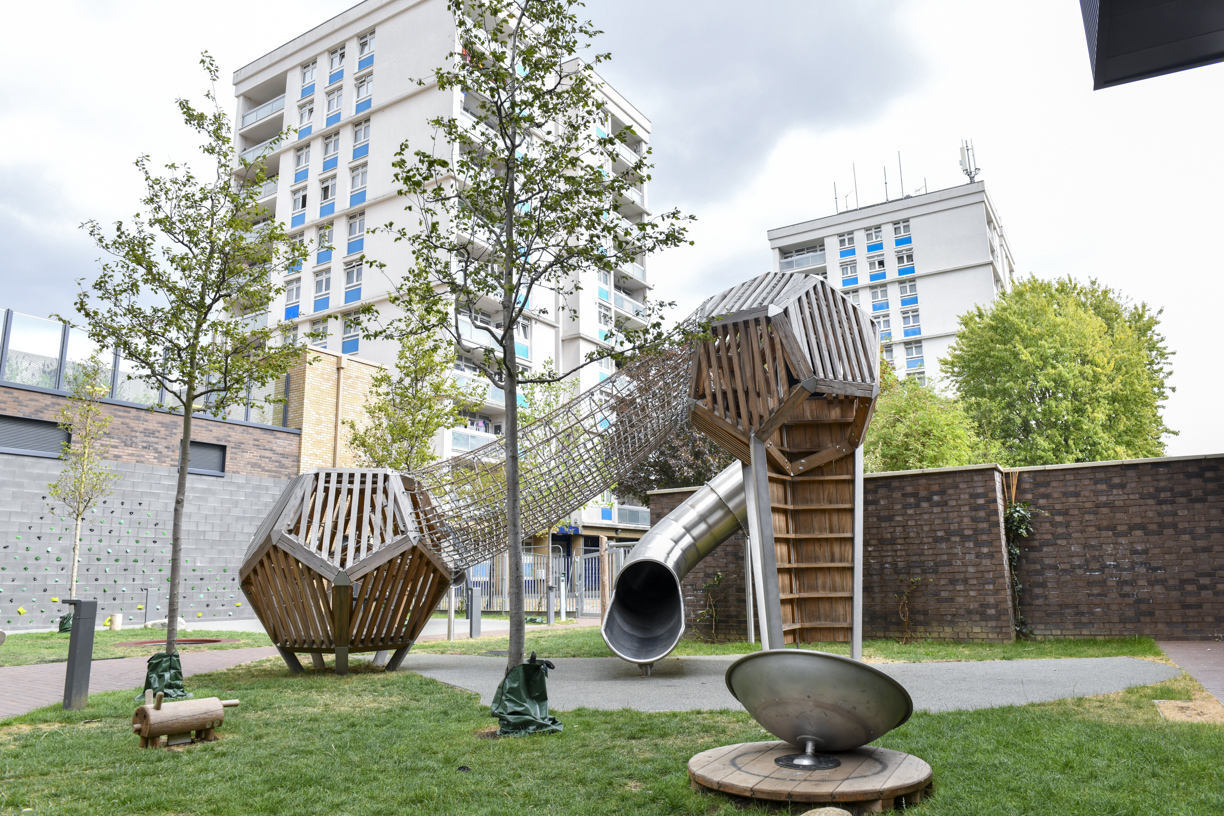 The play area at Stroudley Walk with its wooden climbing towers, tunnel slide and roundabout